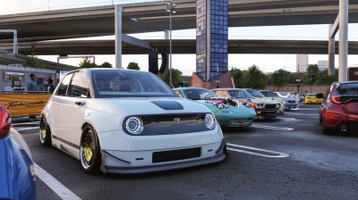 A slammed kei-style hatchback pulling into a car meet under the expressway with the rest of the crew.