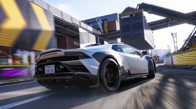 A Lamborghini tearing through one of the industrial dockside circuits at sunset.