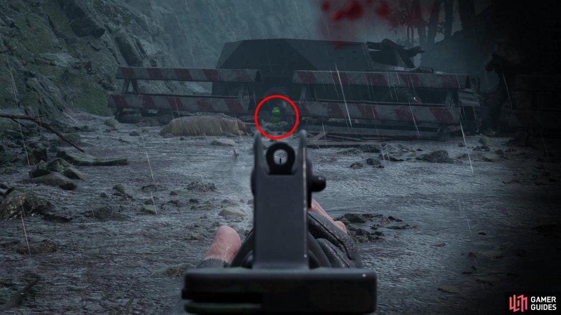 After fighting the Shagohod you’ll get another chase sequence. Near the end of this area Eva will drive uphill towards some white and red roadblocks. This Kerotan is on the ground between them.