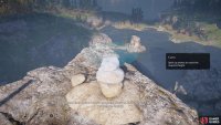 Next, place one of the smaller stones on top. Be careful not to drop the rock too hard or you&rsquo;ll knock the stack over.