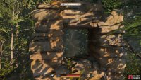 To the right of the boulders, you’ll find a piece of wall with a window through it. This will show you the ruins.